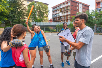 Baseball team celebrating victory with coach holding clipboard on field