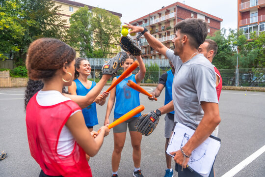 Baseball team celebrating victory with bats and gloves raised high - Powered by Adobe