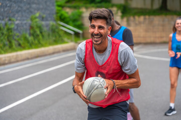 Rugby player smiling and holding ball during training on court
