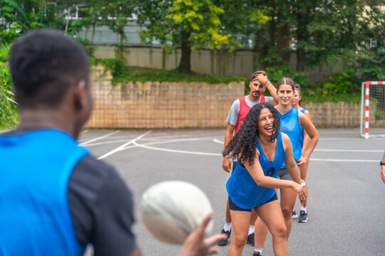 Rugby players passing the ball during training on a court
