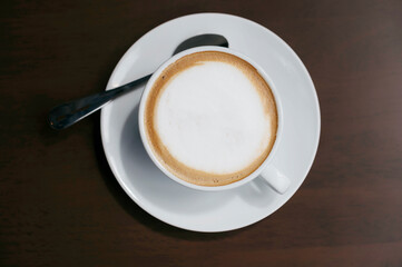 Fresh cappuccino in white cup on table