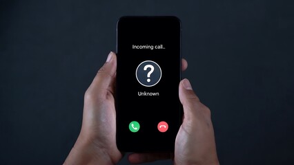 Holding smartphone displaying incoming anonymous call with question mark symbol and accept or reject options, representing mystery and potential danger