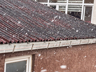 Snowfall on a Red Corrugated Roof in Winter