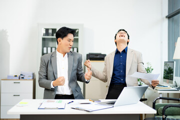 Two excited businessmen cheering with joy in office after success. Concept of teamwork, business win