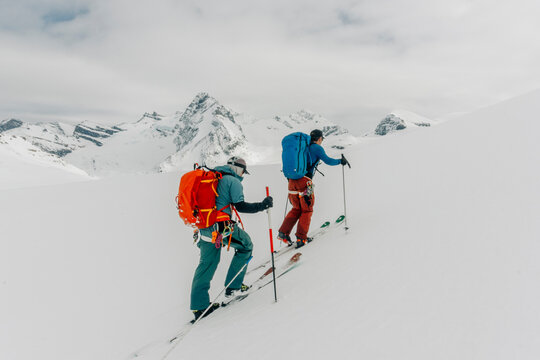 Two men skin up a mountain in the backcountry.
