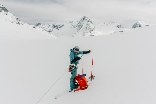 A ski guide preps his gear in the backcountry.