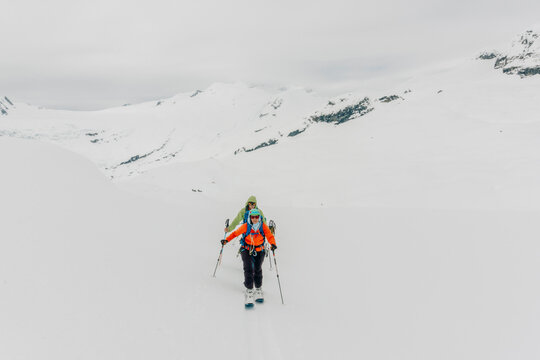 Skiers skin up a mountain in the backcountry.