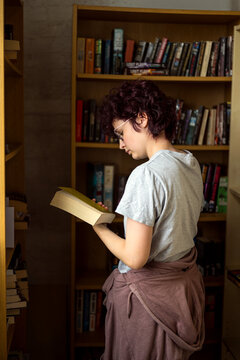 Young teen age girl wearing eye glasses at the book shop library