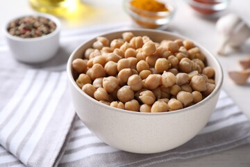 Bowl with delicious chickpeas on table, closeup
