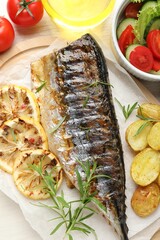 Tasty roasted mackerel served with potatoes and salad on table, flat lay. Homemade seafood dish