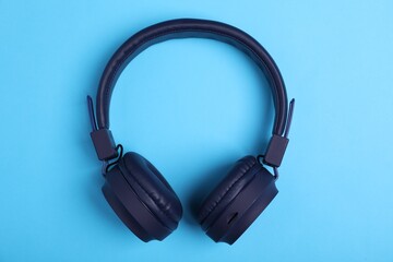 Pair of stylish headphones on light blue background, top view