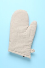 One oven glove on light blue background, top view