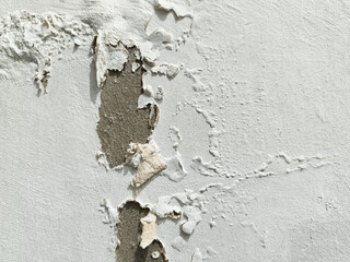 The surface texture of the wall is white with peeling paint.