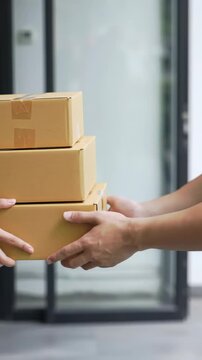 A tight medium close-up video focuses on a professional delivery person's clean hands, in a modern uniform, smoothly handing unbranded brown boxes to a recipient's eager hands, blurred modern