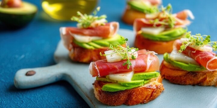 Delicious appetizer with avocado, prosciutto, and microgreens on toast