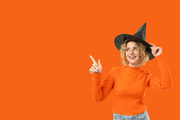Smiling woman with curly hair playfully points for Halloween