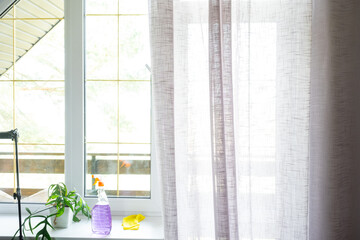 Window cleaning products are lying on the windowsill with a rag, spray, detergent. Spring cleaning in the house, cleaning service