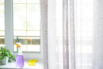 Window cleaning products are lying on the windowsill with a rag, spray, detergent. Spring cleaning in the house, cleaning service