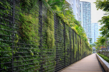 Dense urban greenery on vertical structure, sustainable green fence, and eco-conscious city building exterior.