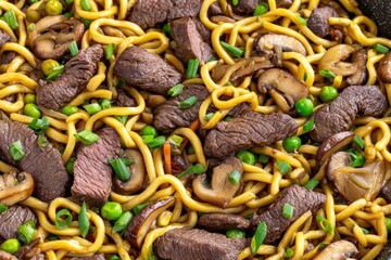 Obraz premium Stir-fried noodles with beef, mushrooms, and peas in a pan