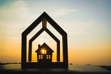 Wooden house silhouette with layered frame and sunlight, symbolizing multi-level home security, protection, peace of mind, family safety, smart housing, and secure residential property.