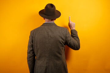 Man in hat pointing upward