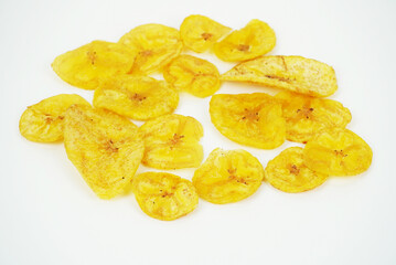 Scattered banana chips on white background in casual flat lay arrangement