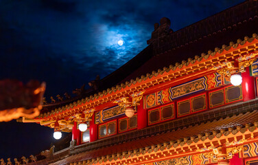 the mist cover the full moon on the top of Taiwanese temple tiles