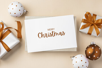 Merry christmas holiday greeting card with gift box with brown bow ribbon and xmas ball decor on light beige background