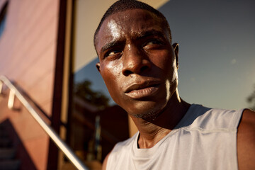 Focused athlete outdoors in warm light with determination and energy on his face