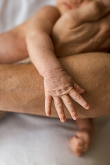 Fototapeta premium Newborn Baby's Hand Holding Adult's Arm