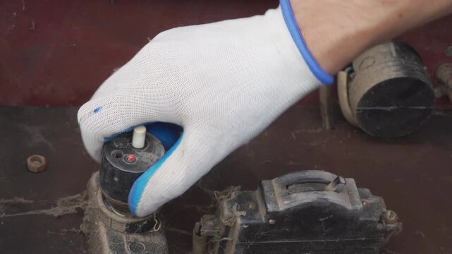 unscrew an old automatic fuse in an electrical panel by hand, electrician unscrews a plug in an old base in a distribution panel