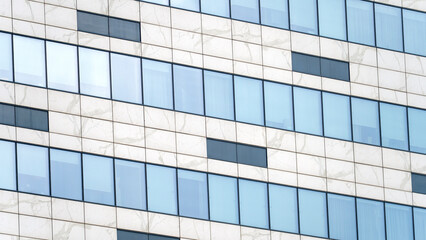 Obraz premium A large building with many windows and a blue tint. The windows are clear and the building is white