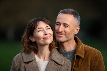 middleaged couple embraces warmly in park during cozy autumn day showcasing their love