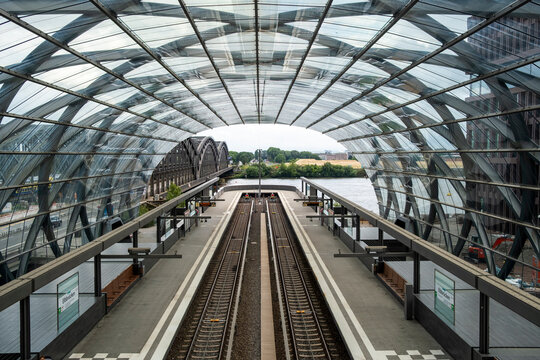 Railway station with glass roof in Hamburg Germany, public transport perspective with parallel tracks, sustainable infrastructure detail, mobility planning and ecofriendly urban circulation
