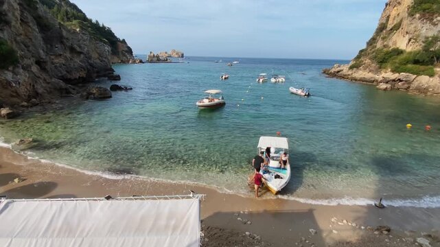 Paleokastritsa, Corfu Greece. 08.09.2025. Boat rentals on the beach of Corfu Island. Tourists rent a boat.