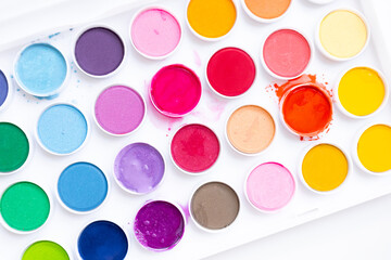 Vibrant watercolor paint set with various bright colors in round containers