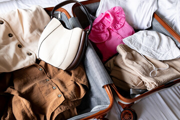 Organized travel essentials with stylish outfits and accessories in suitcase