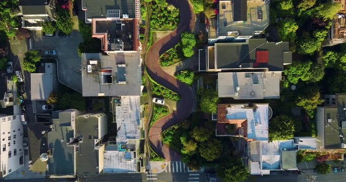 Aerial view of Lombard Street, a winding road with vivid red bricks contrasted by lush green foliage, creating a striking visual, San Francisco, California, United States.
