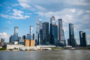 Obraz premium Modern waterfront Manhattan skyline. Skyscrapers near Manhattan's waterfront mirror the sky, blending modern design with urban vibes.