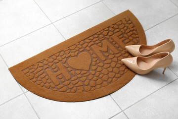 Brown door mat and heels on floor in hallway