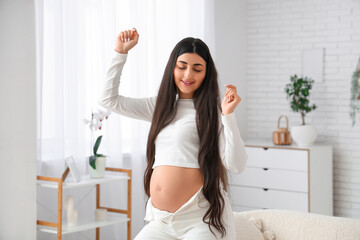 Young pregnant woman dancing at home