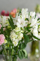 Vibrant bouquet of white flowers with green leaves in soft focus