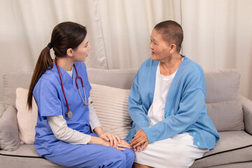 Obraz premium Young female nurse holding hands with senior woman, both smiling with trust and warmth during health support session in cozy home setting, healthcare, caregiver, take care, consult.