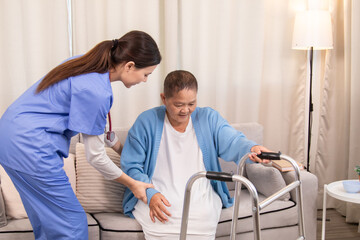 Fototapeta premium Young nurse assisting senior woman in walking with a walker, demonstrating caregiving, encouragement, and physical rehabilitation at home, healthcare, caregiver, medical, hospitality, recover.