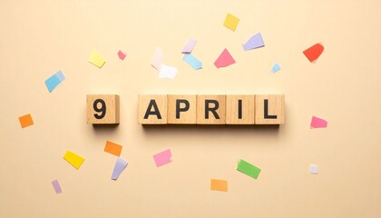 Wooden Blocks with Date 9 April. Calendar for birthday or anniversary on solid colored background with confetti