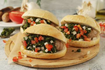 Choripan - bread with grilled sausages with chimichurri sauce, traditional Argentinian fast food dish