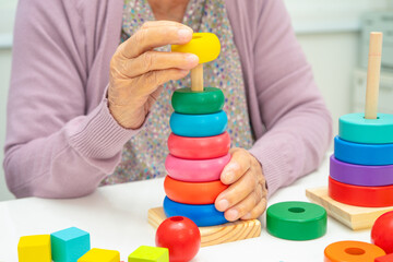 Alzheimer disease AD, Asian elderly woman patient suffering from dementia learn practical motor skills rehabilitation.