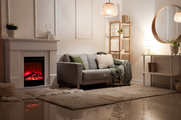 Cozy interior of dark living room with fireplace and sofa near white wall