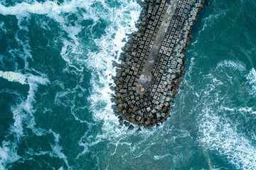 Top-down aerial view of a breakwater surrounded by turquoise water, Abstract Texture